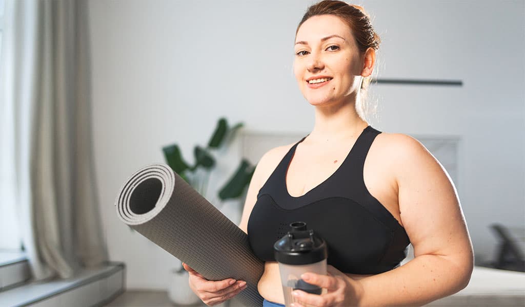 Active woman with yoga mat representing GLP-1/GIP combination therapy at Body Slim Atlanta